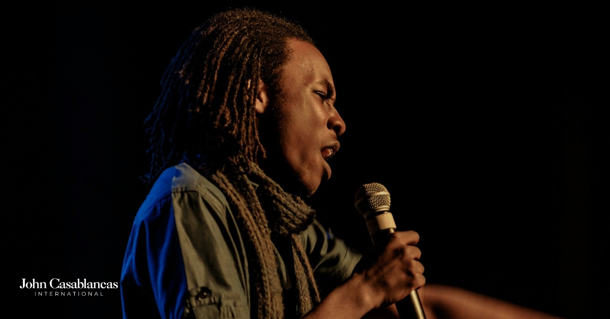 a singer belting into a microphone on stage