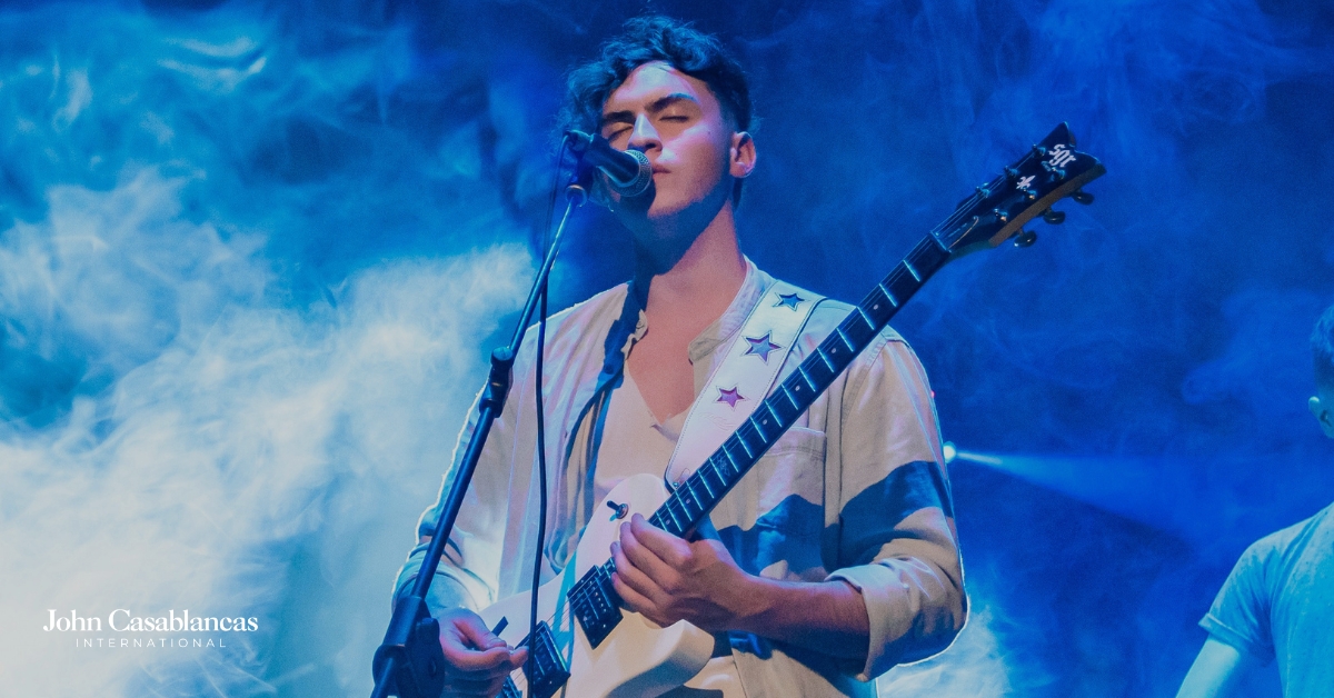 a singer performing on stage and playing a guitar
