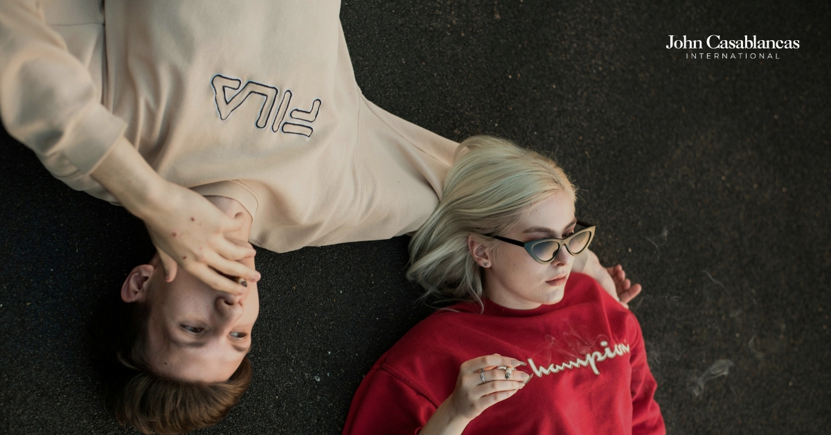 two models laying on the ground and striking a pose