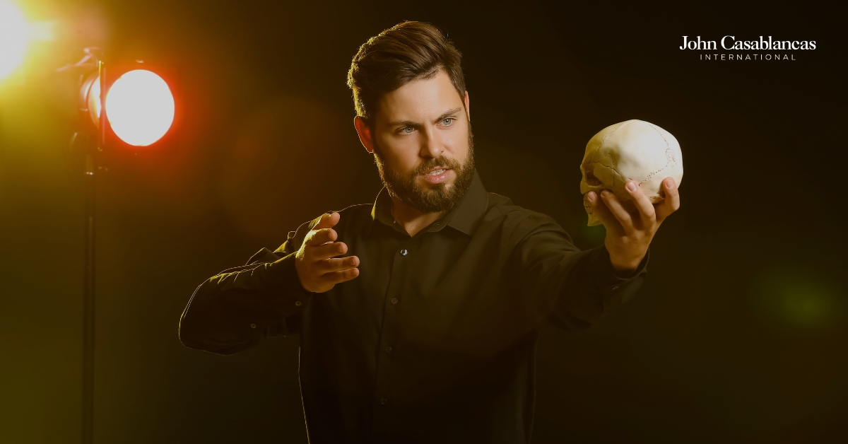 a man performing a monologue while holding a skull